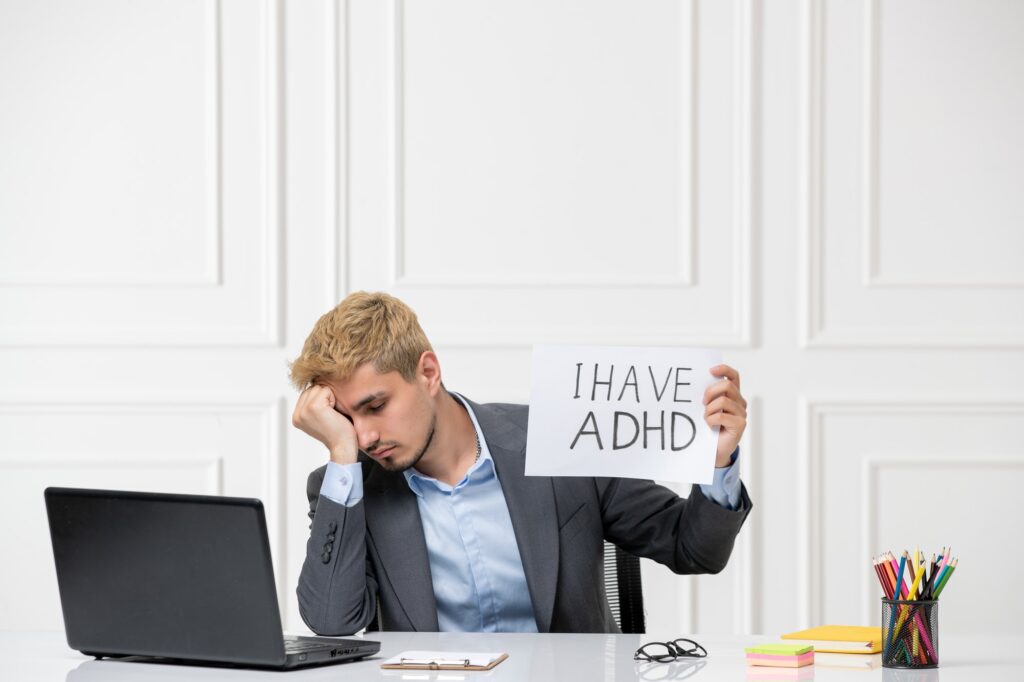 ADHD cute young stressed worker in the office behind desk with computer very tired and sleepy