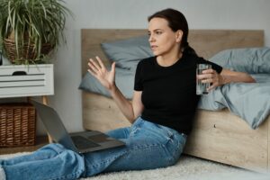 Reflective Moment: Woman Engrossed in Online Therapy