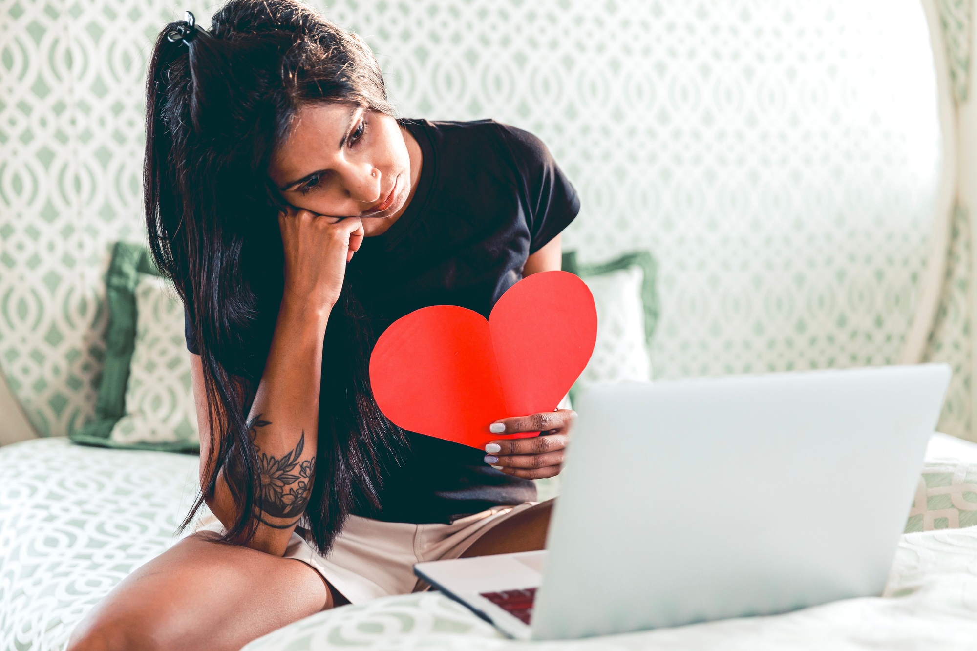 A woman sad, chatting with her lover, holding a heart, love during COVID, long distance relationship