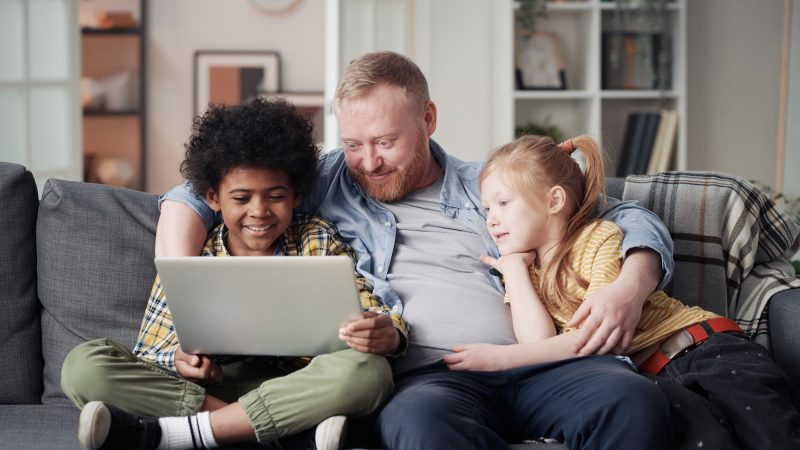 Father with children using laptop at home